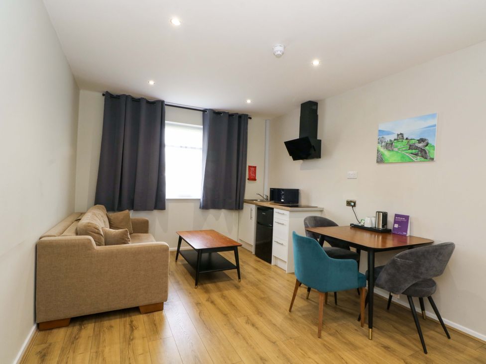 A living room with a sofa and dining area at 2 bed no. 6 Chorley