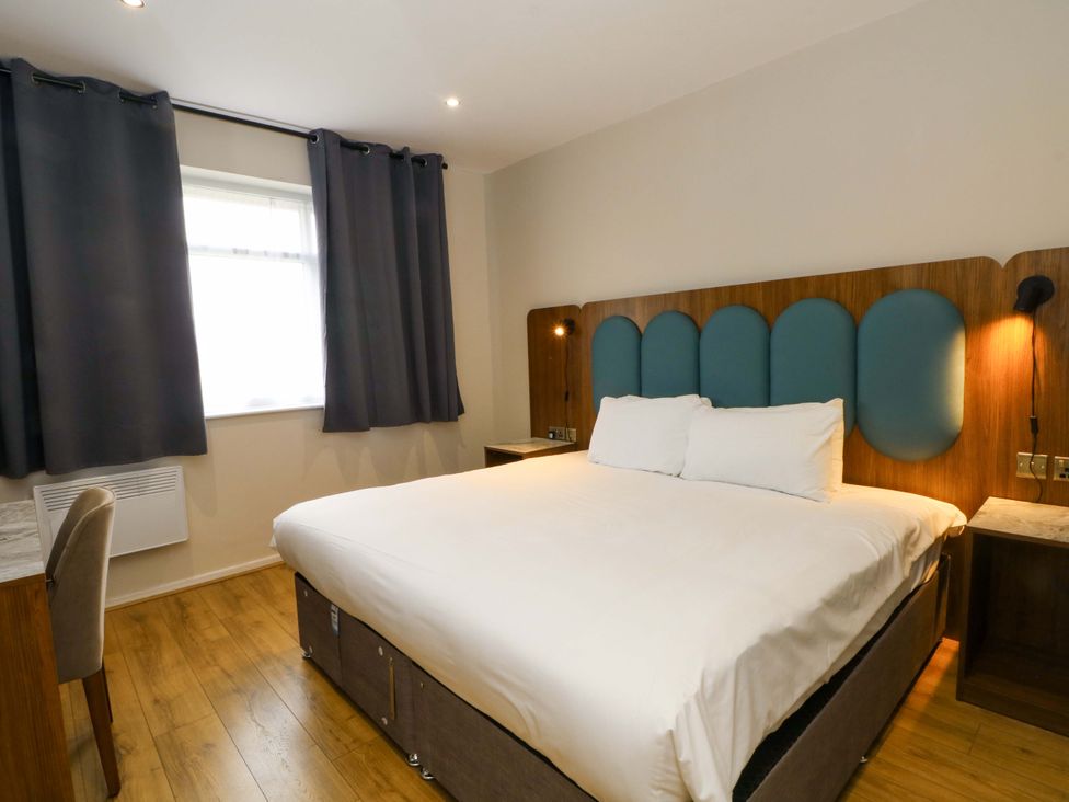 A bedroom with a bed and a chair at 2 bed no. 6 Chorley