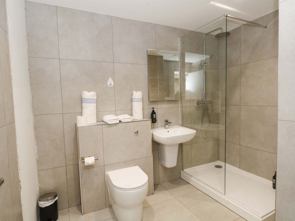 A bathroom with a shower, toilet, and washbasin at 2 bed no. 6 in Chorley