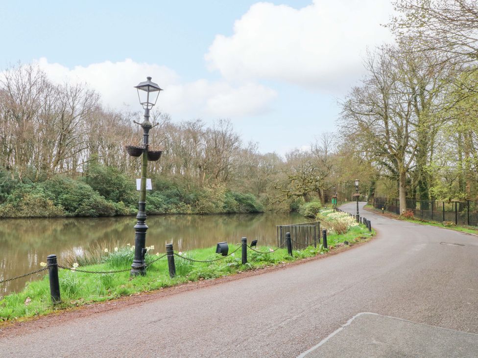 A pathway beside a river with lamp posts and trees at 2 bed no. 6 Chorley