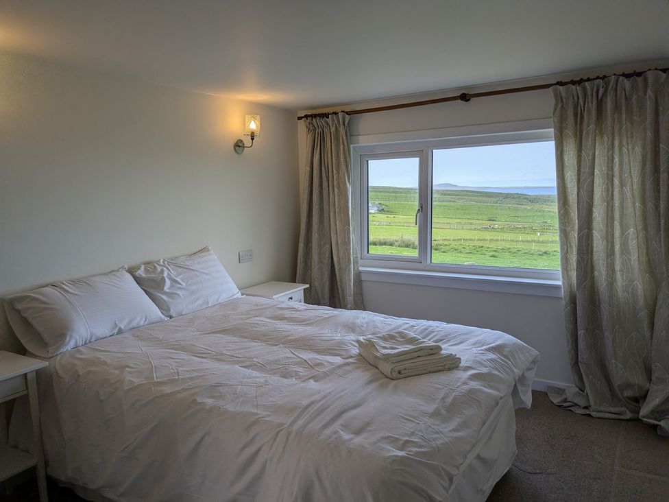 A bedroom with a bed and a window at Rousey Cottage Rousay, Orkney Islands
