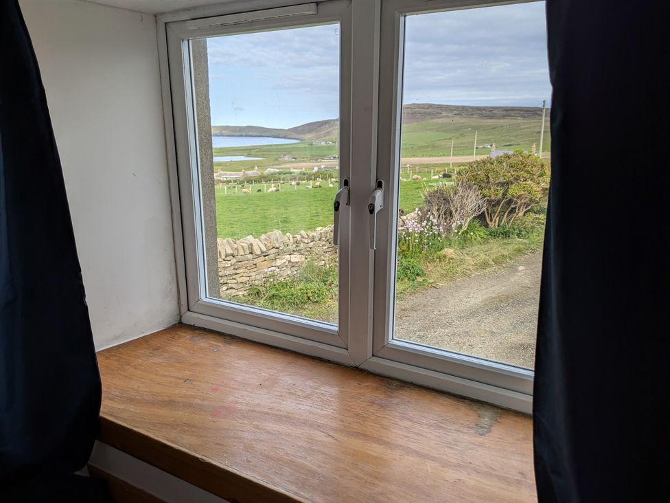 A window with a view of the landscape at Rousey Cottage in Rousay, Orkney Islands
