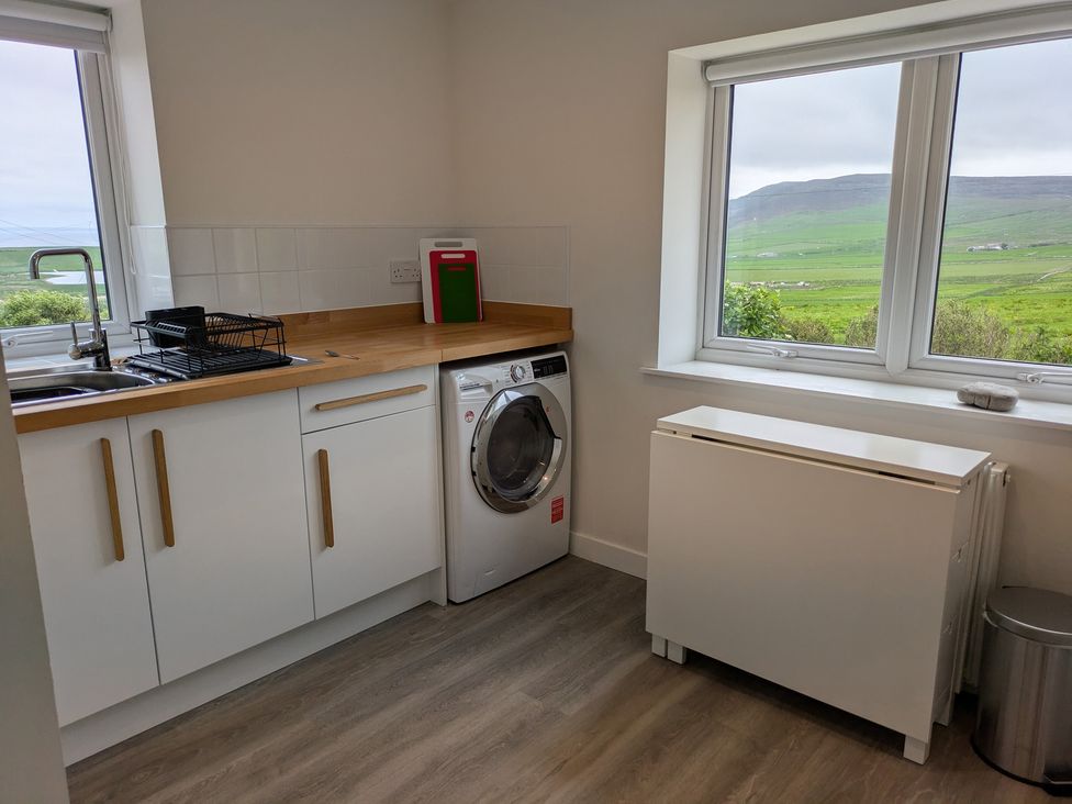 A kitchen with a washing machine and sink at Lower Hammerfield Rousay, Orkney Islands