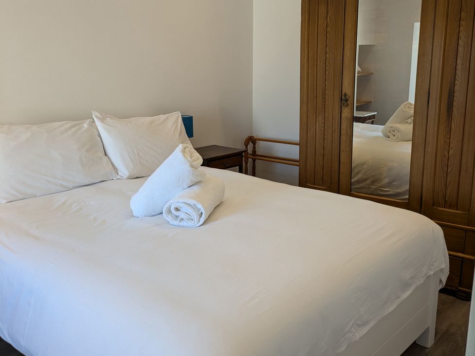 A bedroom with a bed and towels at Lower Hammerfield Rousay, Orkney Islands