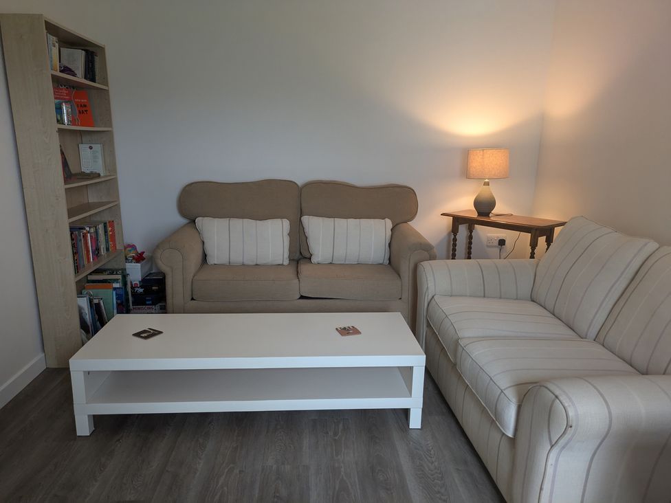 A living room with a sofa and coffee table at Lower Hammerfield, Rousay, Orkney Islands