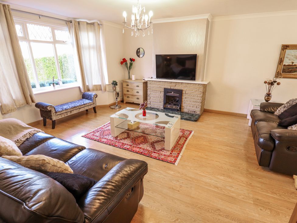 A living room with a sofa, armchair, coffee table and television at 55 Broadway in Lincoln
