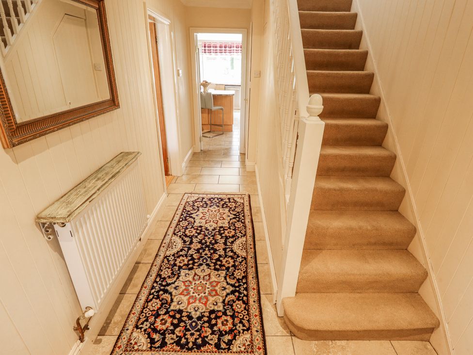 A hallway with a staircase, radiator, and rug at 55 Broadway in Lincoln