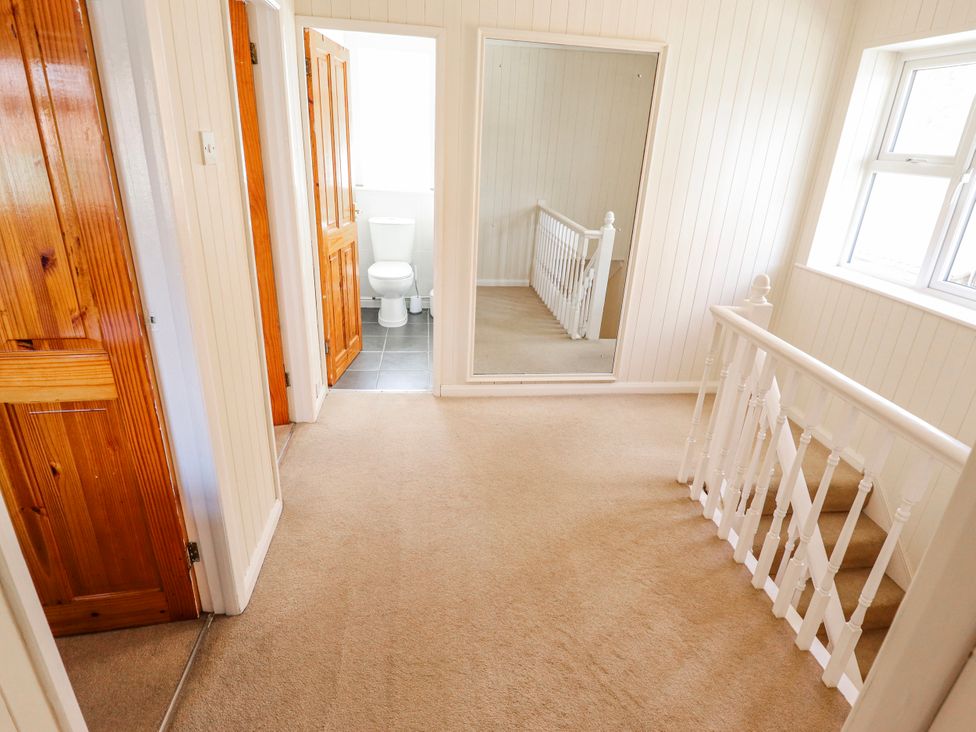 A hallway with a mirror and doors at 55 Broadway Lincoln