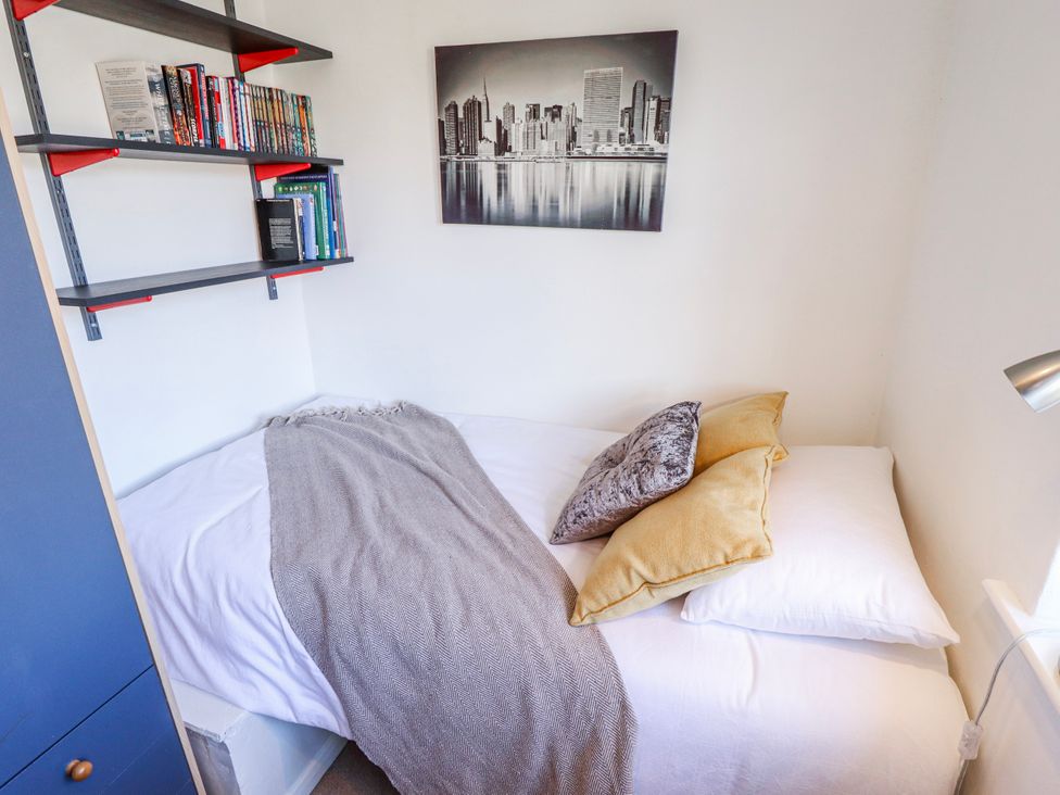 A bedroom with a bed and books on shelves at 55 Broadway in Lincoln