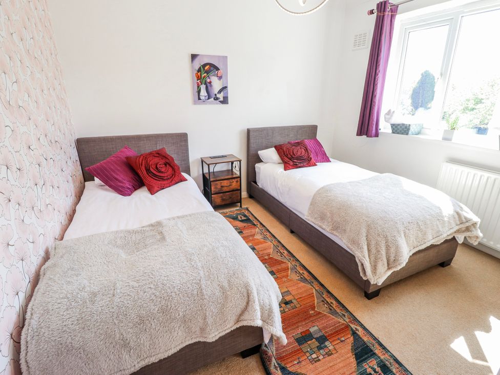 A bedroom with two single beds and a window at 55 Broadway in Lincoln