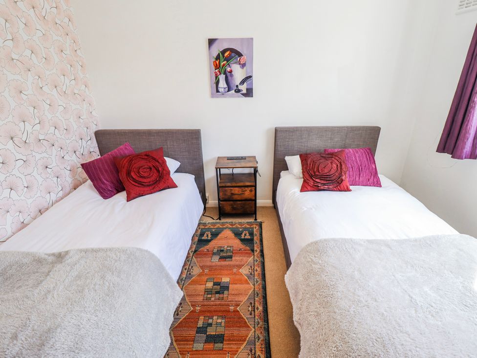 A bedroom with two single beds and a bedside table at 55 Broadway in Lincoln