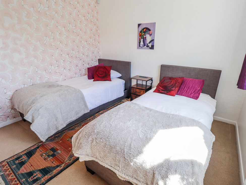 A bedroom with two beds and a bedside table at 55 Broadway in Lincoln