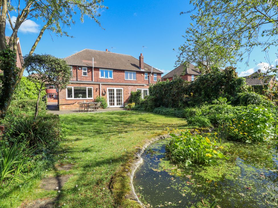 A garden with a house, table, and chairs at 55 Broadway in Lincoln