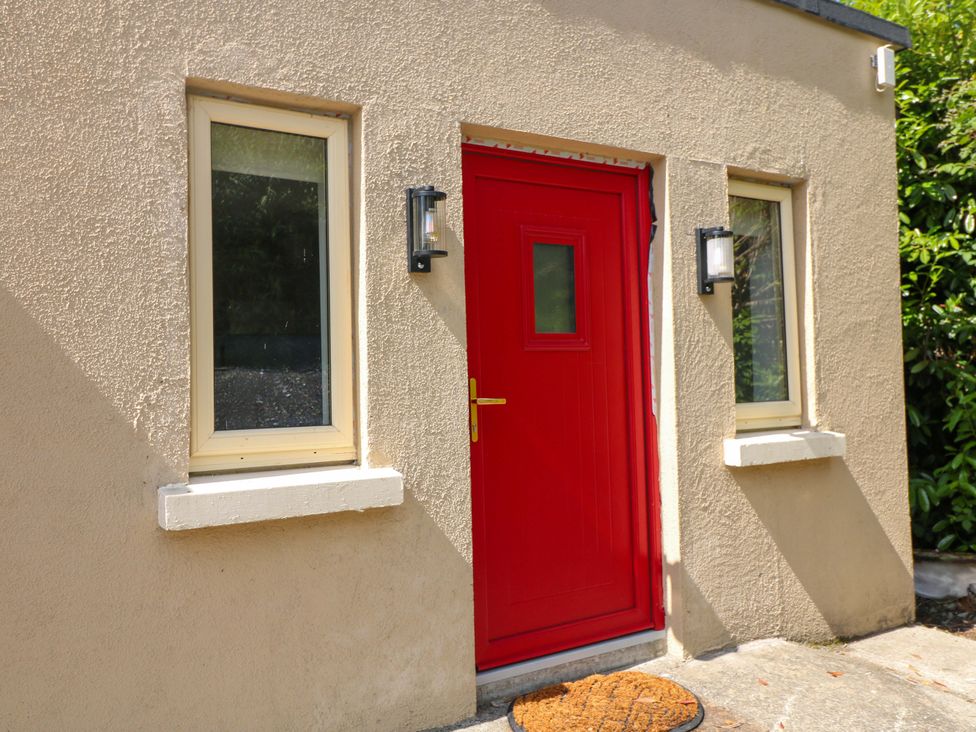 A red door with windows and light fixtures at The Mews @ Suskar, Laragh, County Wicklow