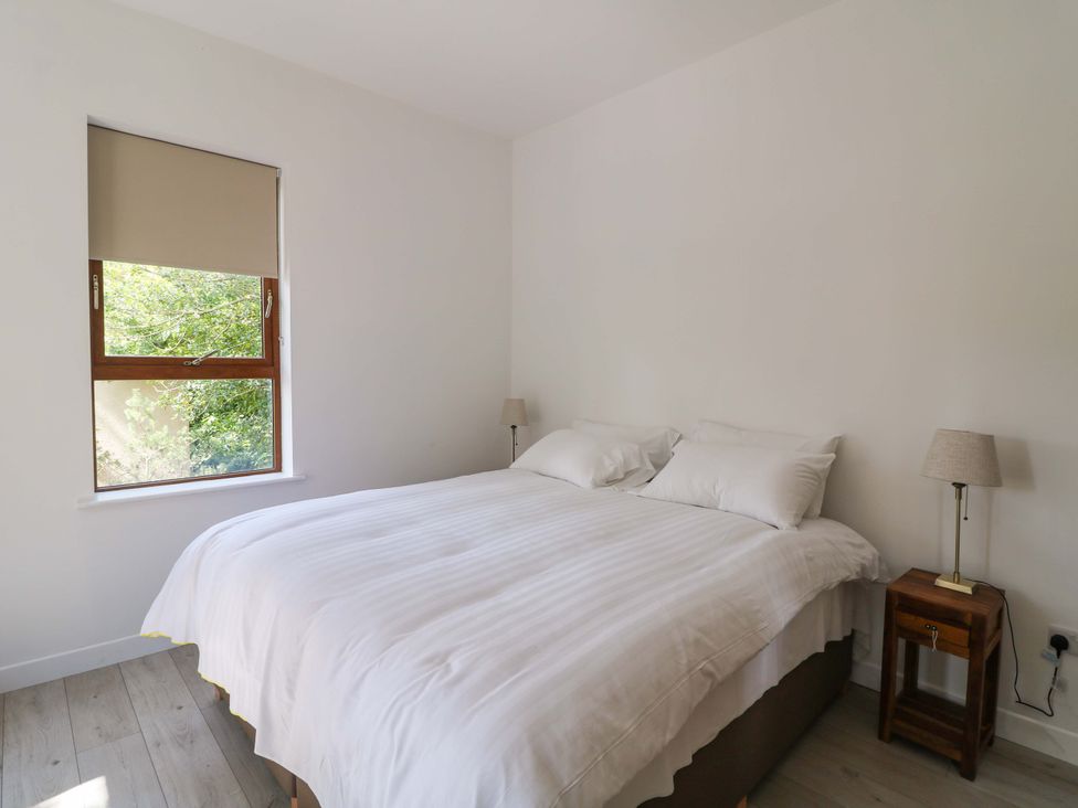 A bedroom with a bed and bedside tables at The Mews @ Suskar, Laragh, County Wicklow