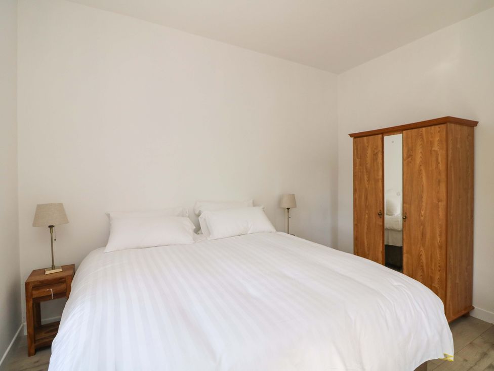 A bedroom with a bed and a wardrobe at The Mews @ Suskar, Laragh, County Wicklow