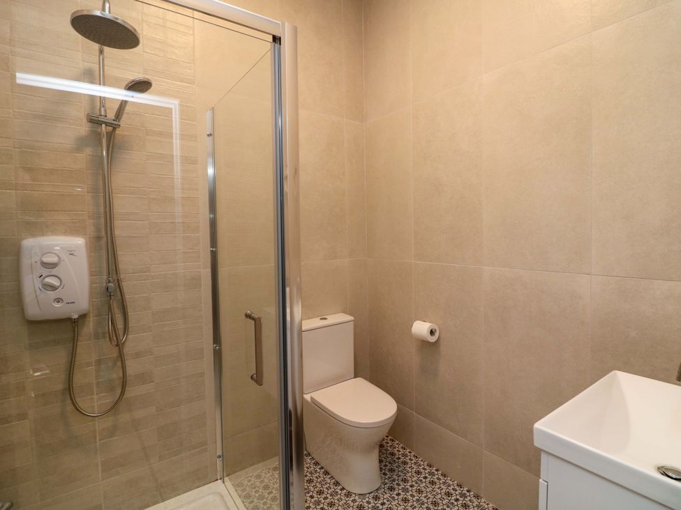 A bathroom with a shower, toilet, and sink at The Mews @ Suskar, Laragh, County Wicklow