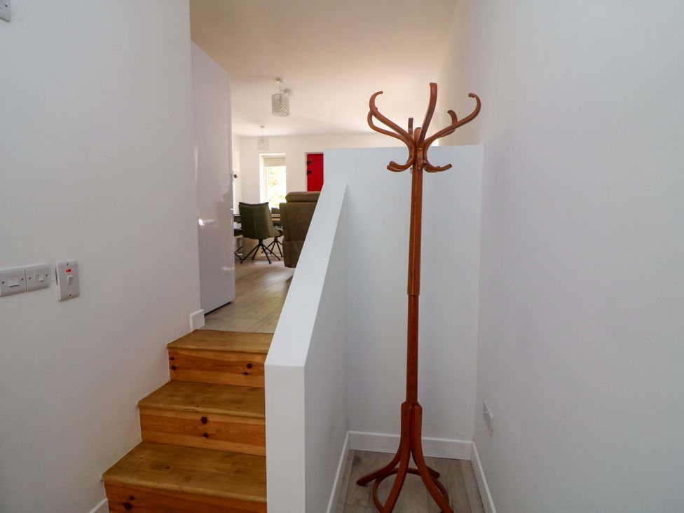 A hallway with a coat stand and stairs at The Mews @ Suskar, Laragh, County Wicklow