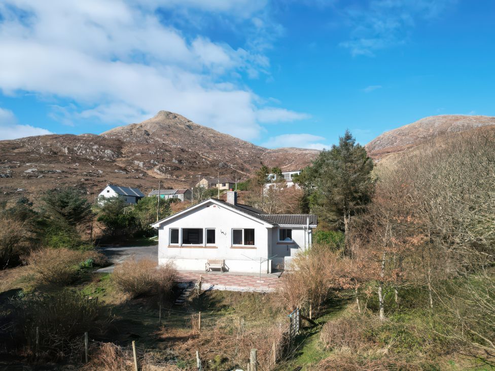 A house with a mountain backdrop at Woodview in Isle of Barra
