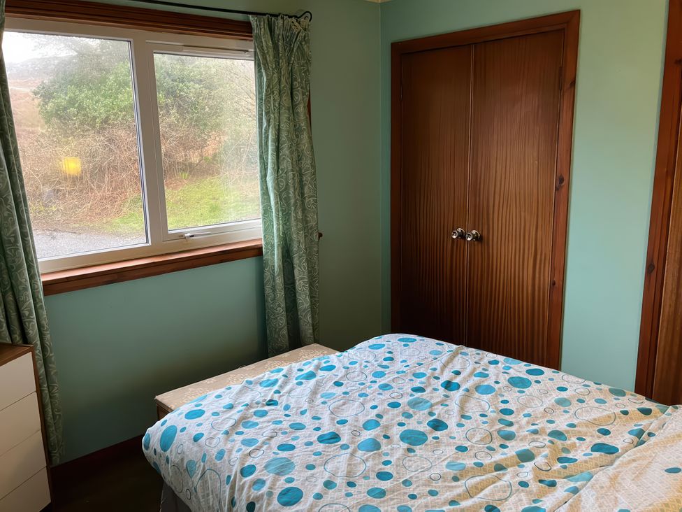 A bedroom with a bed and window at Woodview in Isle of Barra
