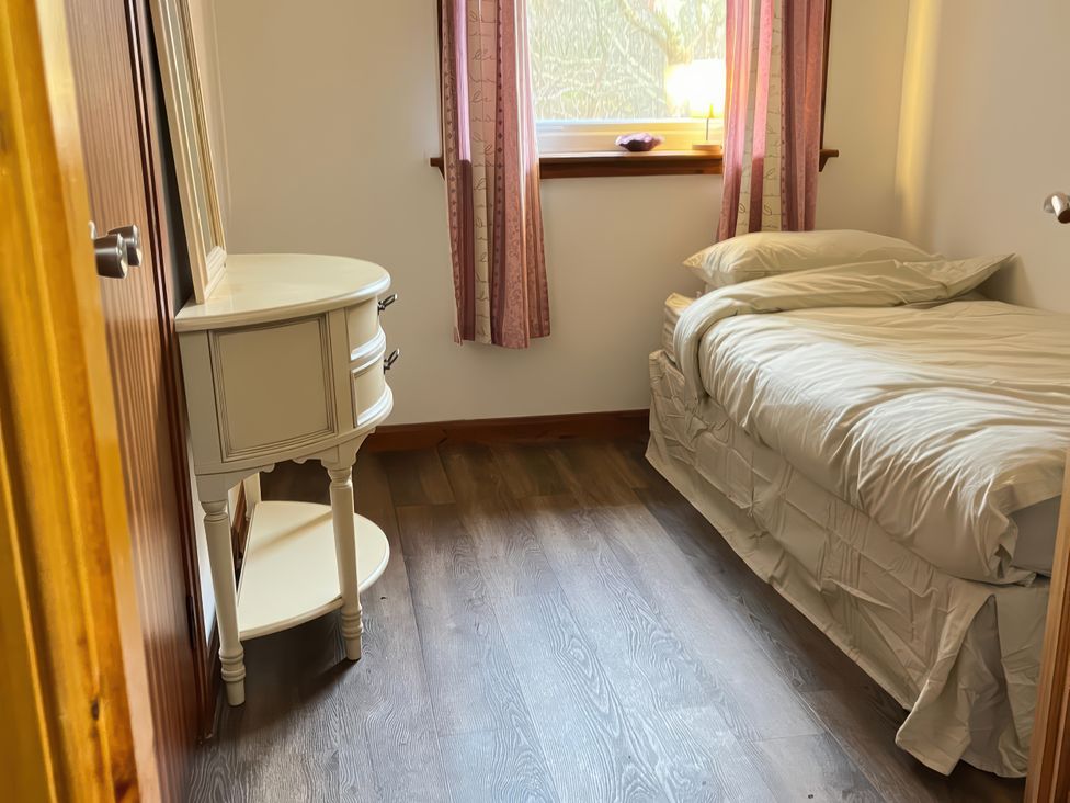 A bedroom with a bed and a drawer at Woodview Isle of Barra