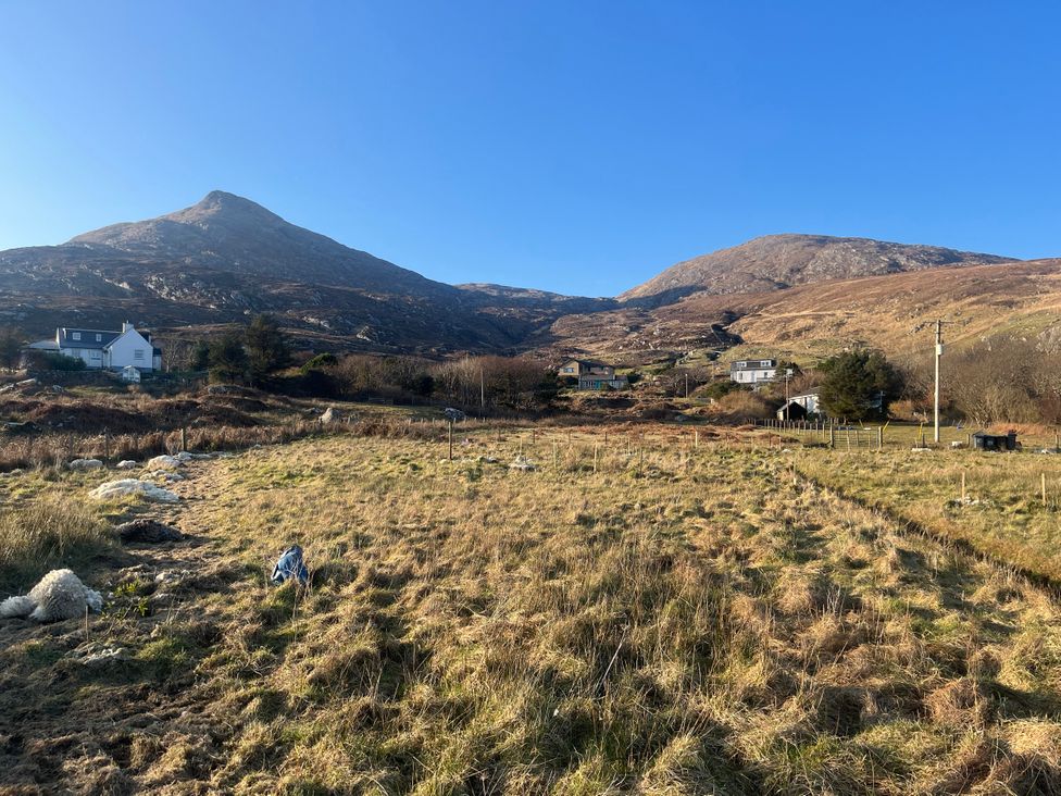 An outdoor view of mountains and houses at Woodview in Isle of Barra