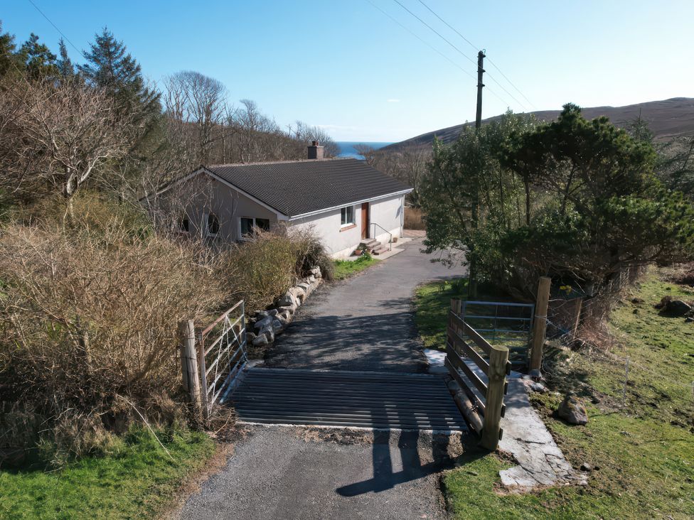 A house with a gate and driveway at Woodview in Isle of Barra