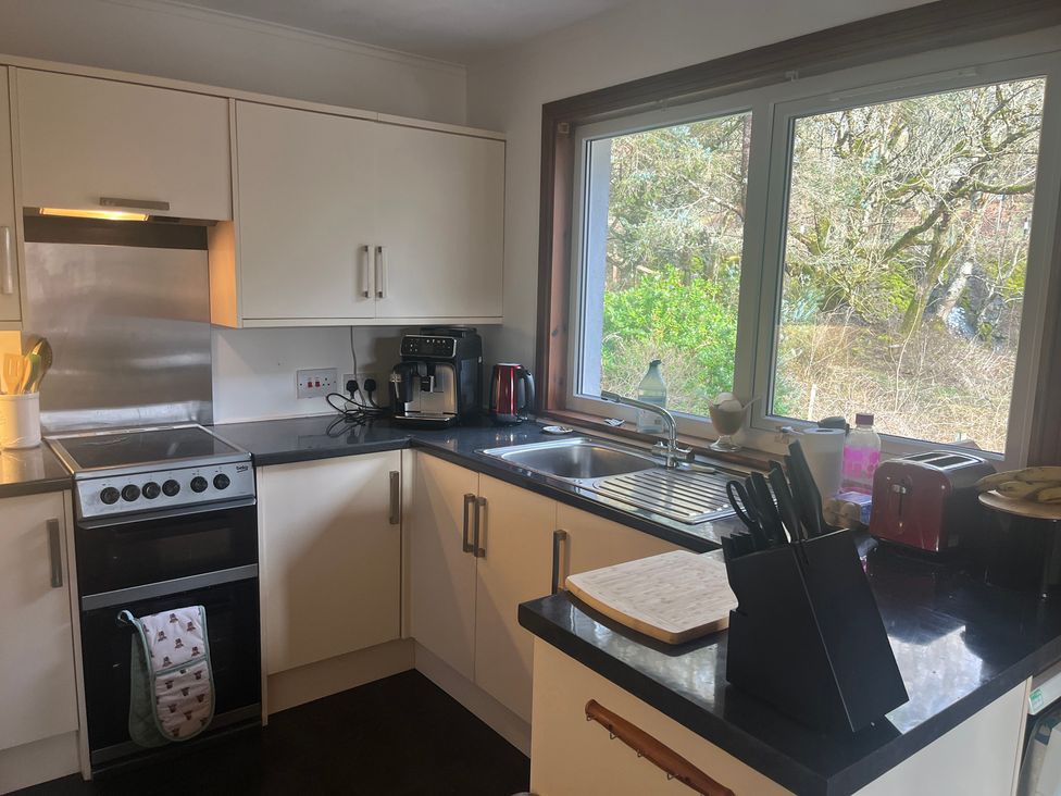 A kitchen with cabinets and appliances at Woodview, Castlebay, Isle Of Barra