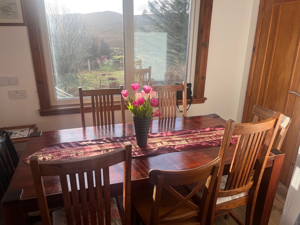 A dining room with a table and chairs at Woodview, Castlebay, Isle Of Barra