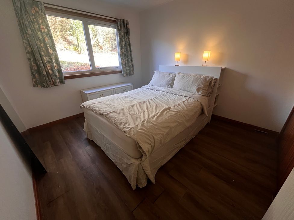 A bedroom with a bed and window at Woodview, Castlebay, Isle Of Barra