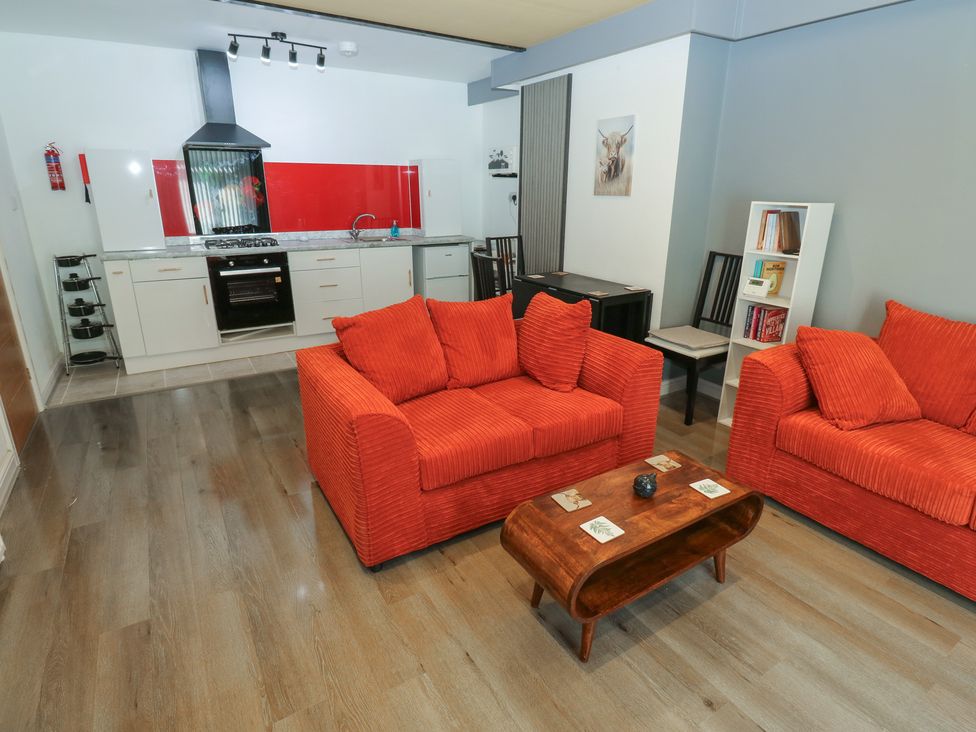 A living room with a kitchen area and two sofas at No.1 Spa Mill Lodge in Huddersfield