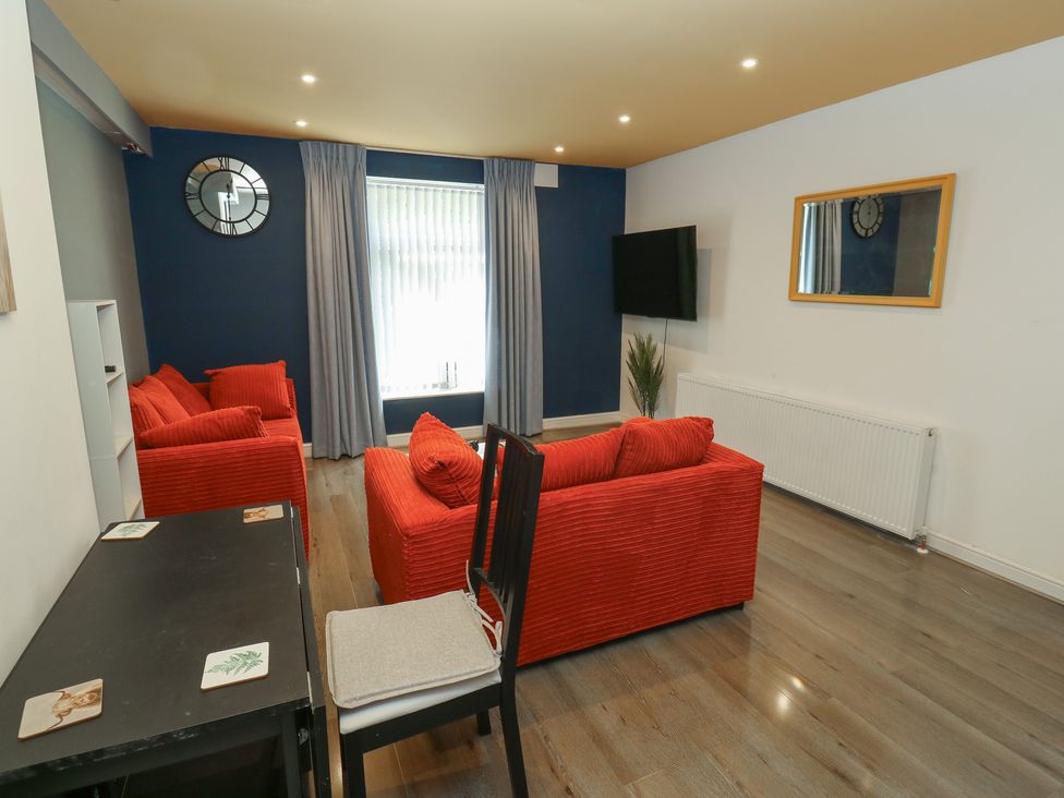 A living room with a sofa, table and television at No.1 Spa Mill Lodge in Huddersfield
