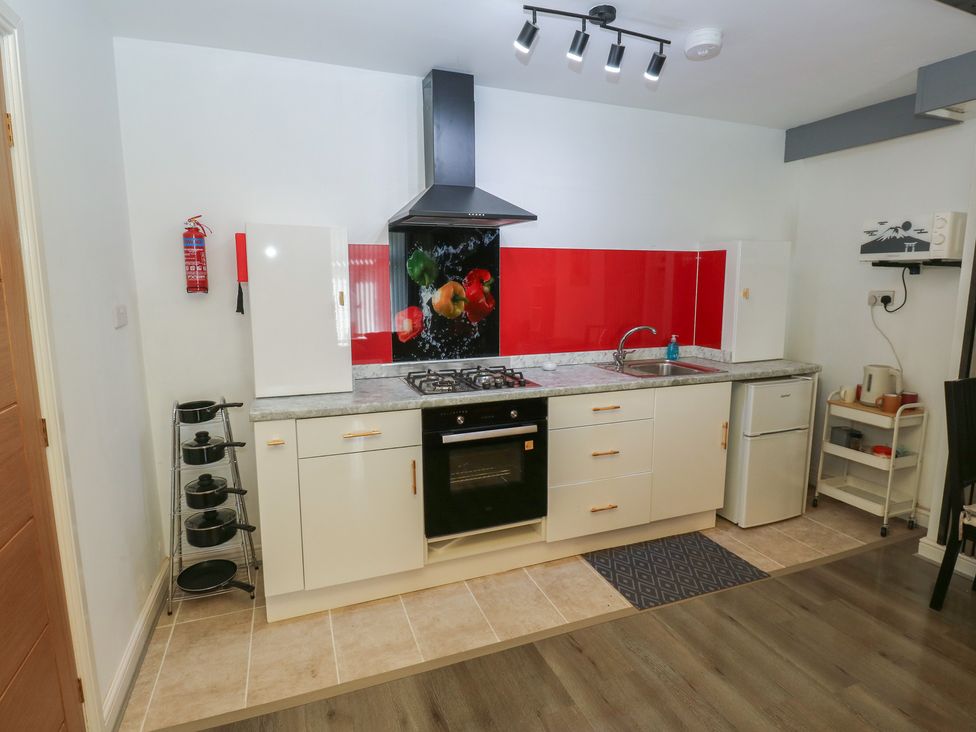 A kitchen with a cooker, fridge, and sink at No.1 Spa Mill Lodge in Huddersfield