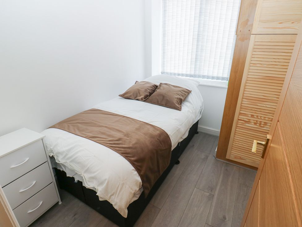 A bedroom with a single bed and a nightstand at No.1 Spa Mill Lodge in Huddersfield