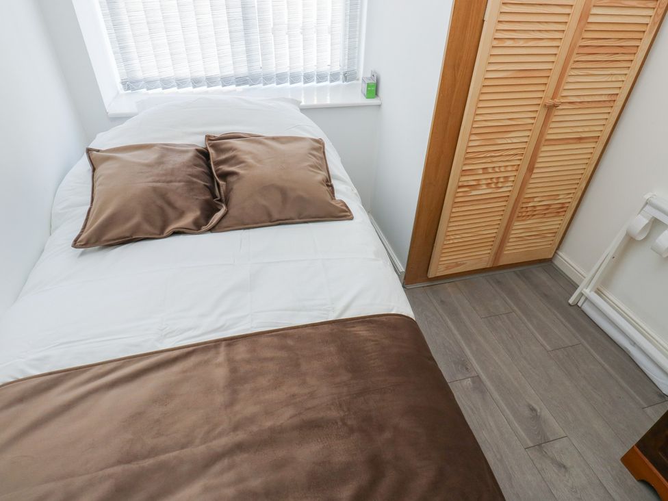A bedroom with a bed and wardrobe at No.1 Spa Mill Lodge in Huddersfield