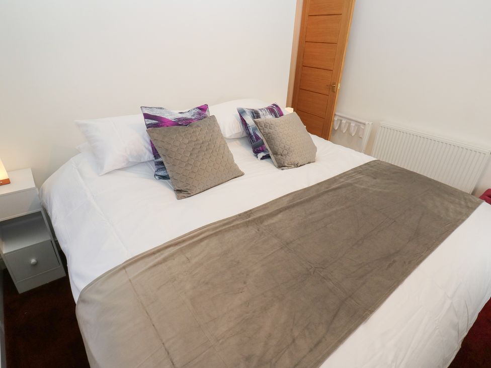 A bedroom featuring a bed with pillows and side lamp at No.1 Spa Mill Lodge in Huddersfield