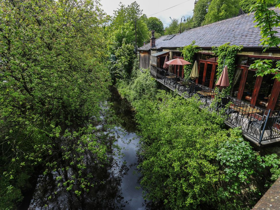 A building with a balcony overlooking a waterway at No.1 Spa Mill Lodge in Slaithwaite
