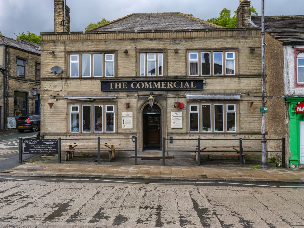 A pub exterior with signage and seating at No.1 Spa Mill Lodge Slaithwaite