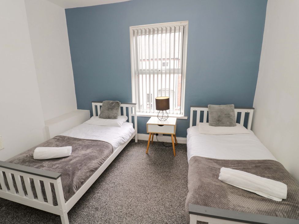 A bedroom with two single beds and a lamp at 1C Highfield Road - 2 bed Rowley Regis