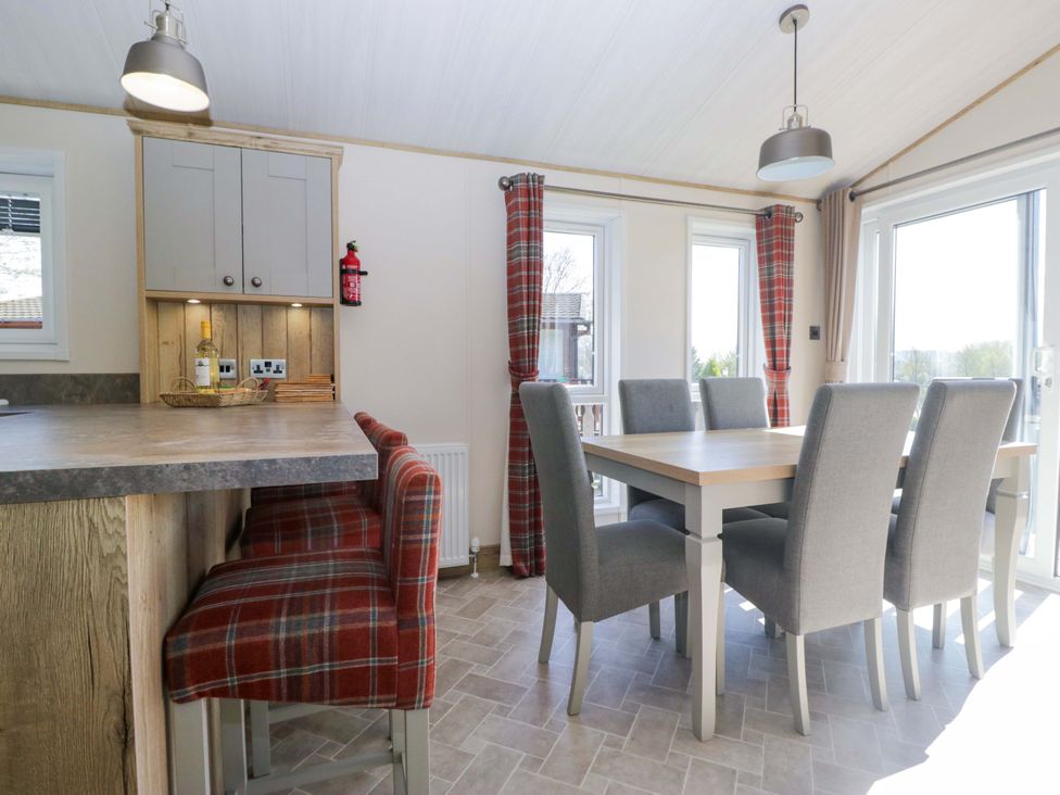 A dining room with a table and chairs at Borwick Heights 17 Carnforth