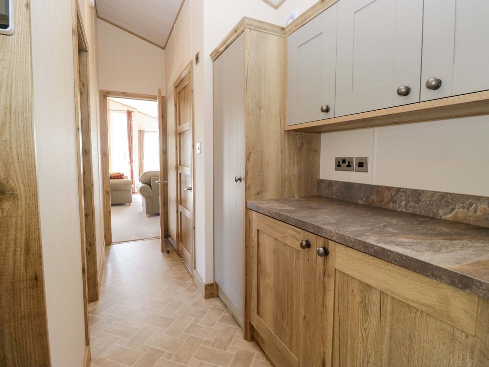 A hallway with cabinets and a door at Borwick Heights 17 Carnforth