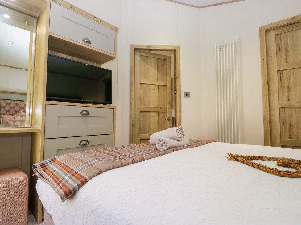 A bedroom with a bed and television at Borwick Heights 17 Carnforth