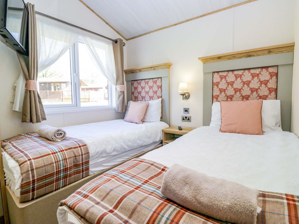 A bedroom with two single beds and a window at Borwick Heights 17 Carnforth