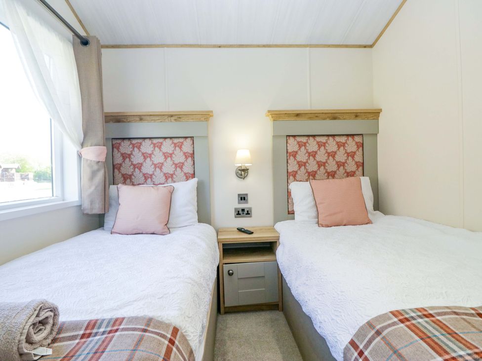 A bedroom with two beds and a bedside table at Borwick Heights 17 Carnforth