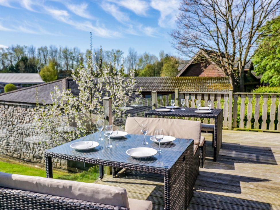 An outdoor dining area with tables and chairs at Borwick Heights 17 Carnforth