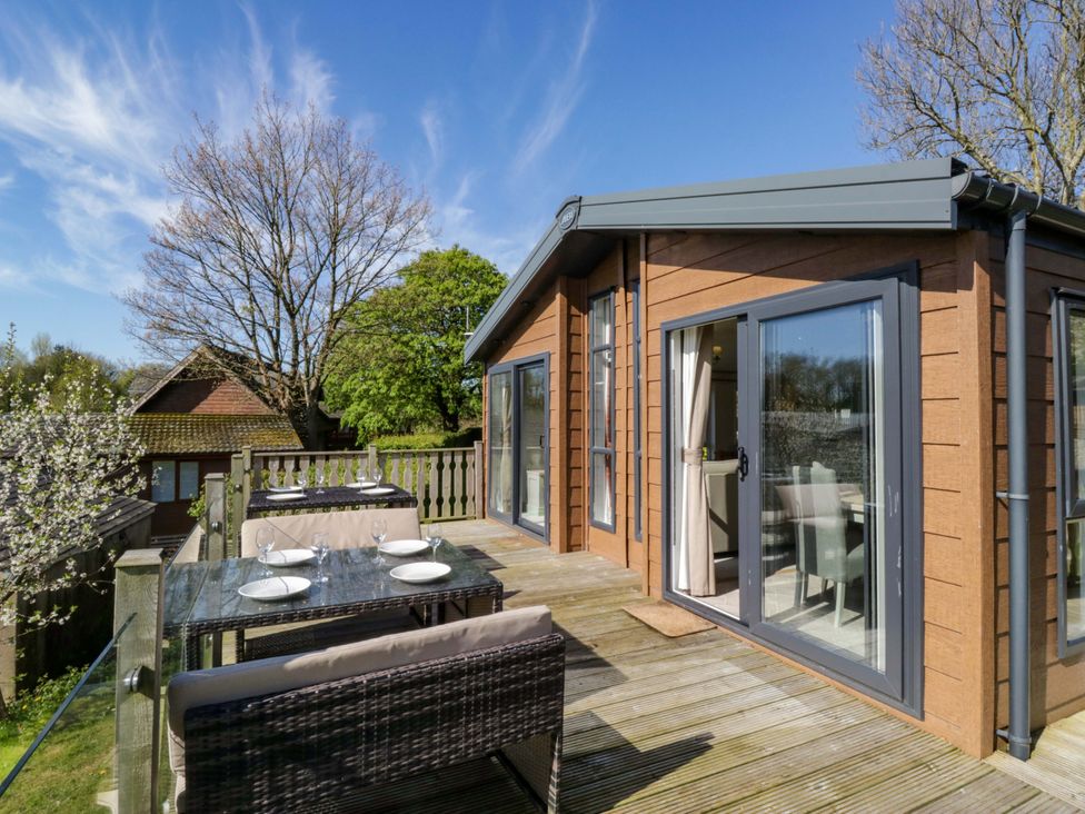 An outdoor area with a table and chairs at Borwick Heights 17 in Carnforth