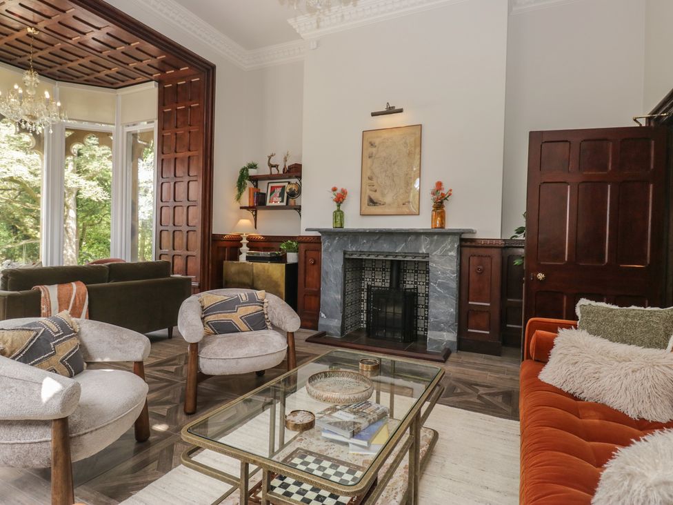A living room with a fireplace and seating area at Brettargh Holt Mansion near Levens