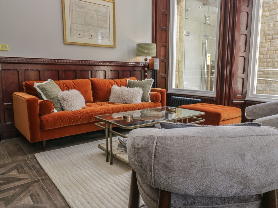 A living room with an orange sofa and coffee table at Brettargh Holt Mansion near Levens