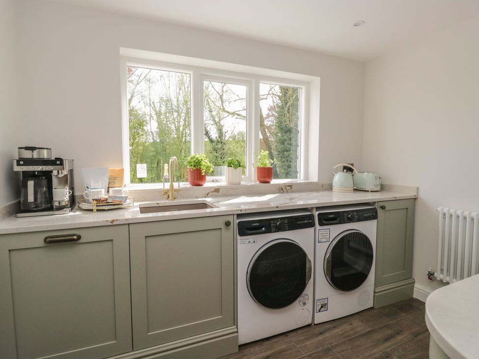 A kitchen with a washing machine and dryer at Brettargh Holt Mansion near Levens