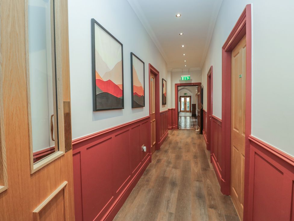 A hallway with paintings on the wall at Brettargh Holt Mansion near Levens